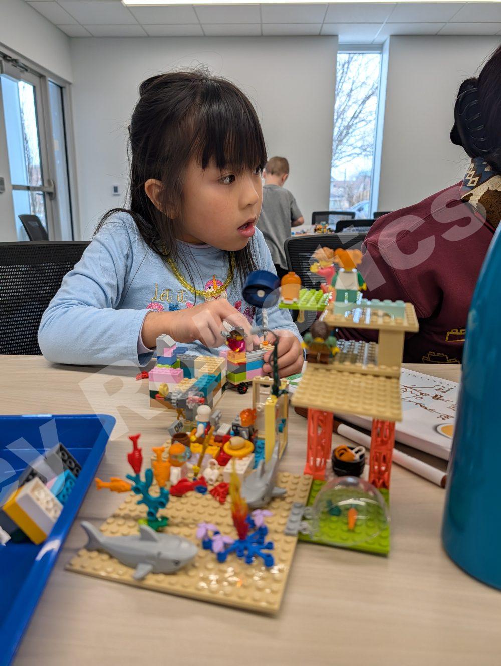 Child playing with colorful Lego set