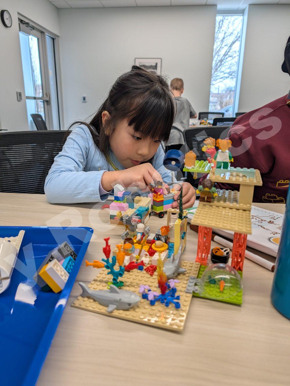 Child building with colorful LEGO blocks