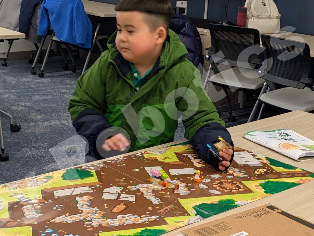 A young student examining a project map on a table during a 2025 Fall Program class at Valley Robotics Club.