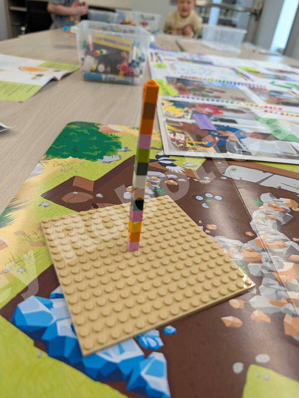Two students focusing on their Lego model projects across a table in a well-stocked classroom during a 2025 Fall Program class.