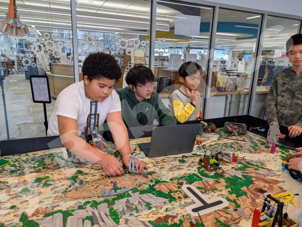 A student coach assisting elementary schoolers with their Lego robotics project during a 2025 Fall Program class at Valley Robotics Club.