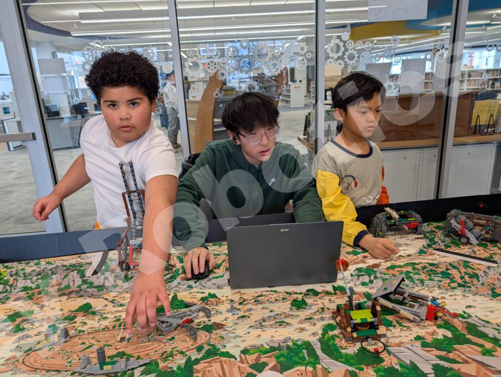 A student coach assisting elementary schoolers with their Lego robotics project during a 2025 Fall Program class at Valley Robotics Club.