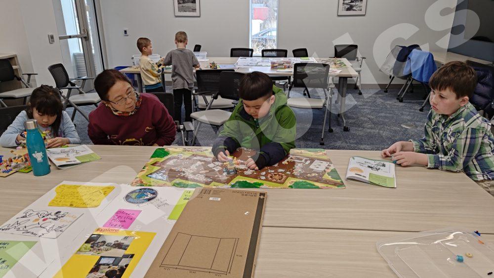 A teacher guiding kids as they build Lego models during a 2025 Fall Program class at Valley Robotics Club.